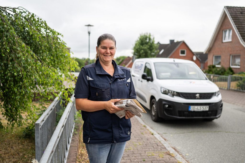 Glückliche Frau mit Zeitung in der Hand